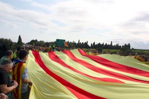 Els assistents han desplegat una gran bandera catalana a la frontera administrativa entre Catalunya i el País Valencià