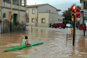 Imatges d'un veí de Bordils amb un kayak remant pels carrers del municipi
