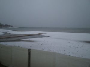 Curiosa imatge de la platja de Roses amb la neu en primer pla i el mar al darrera