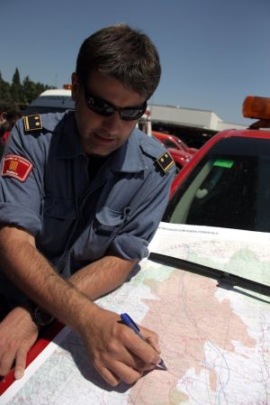 Un bomber situa sobre un mapa una de les zones més complicades de l'incendi de l'Alt Empordà, al sud de Boadella