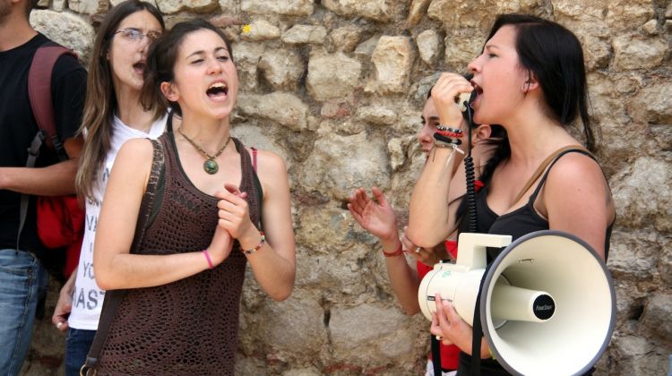 Dues joves de la UdG cridant proclames en contra de la rectora © ACN