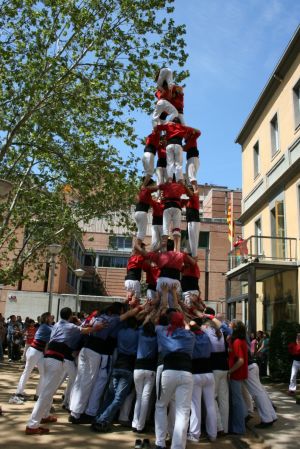 Aquesta fotografia mostra el moment en que l'anxaneta ja ha carregat el castell, amb estructura quatre de set, i inicia el descens.