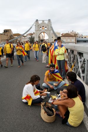 Diversos assistents esperen l'inici de la cadena humana al pont que travessa el riu Ebre a Amposta.