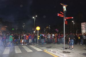 Un jove celebrant el campionat de Lliga damunt un cartell indicador