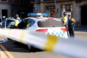 Un vehicle amb agents de la Guàrdia Urbana davant del cordó policial del carrer Pelai de Barcelona