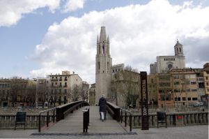 Una persona creuant el pont davant la Catedral i la basílica de Sant Fèlix durant l'estat d'alarma