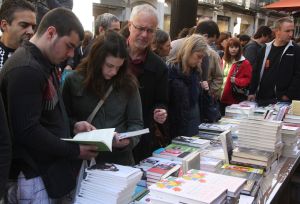 Lectors remenant i triant llibres a la Rambla de Girona.