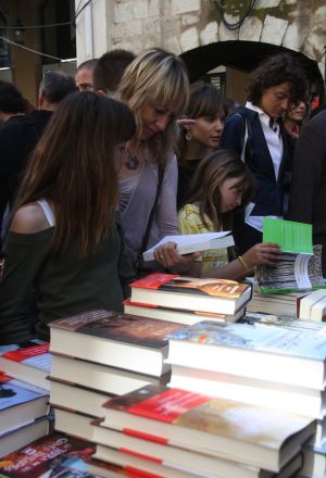 Una mare i les seves filles busquen un llibre per comprar aquest Sant Jordi a Girona.