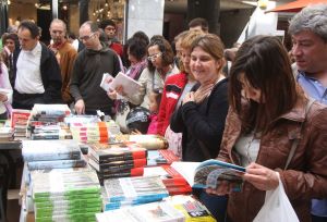 Gent mirant llibres a la Rambla de Girona.