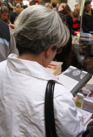 Una dona tria un llibre a Girona.