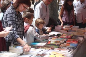 Dos nens cercant un llibre a la rambla de Girona.