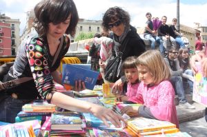 Dues nenes intentant escollir un llibre.