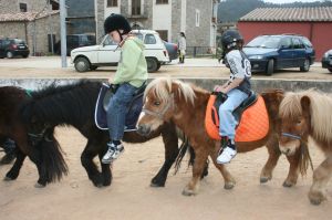 Dons infants passejant damunt un poni