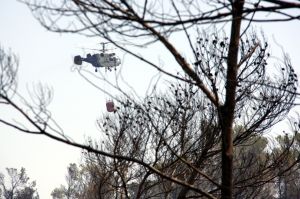 Un helicòpter remulla la zona cremada de l'incendi de l'Alt Empordà, a l'entorn de Boadella