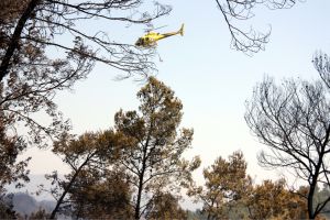 Un helicòpter sobrevola la zona cremada de l'incendi de l'Alt Empordà