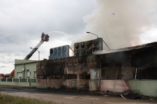 Els Bombers treballen en l'incendi d'una nau industrial a Juià