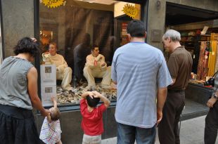Dues persones a l'atur es posen a la venda en un aparador d'un comerç de Figueres