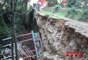 Un camió carregat de troncs s'estimba després de cedir un pont