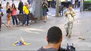 Un home vestit de militar crema una estelada durant l'ofrena a Rafel Casanova