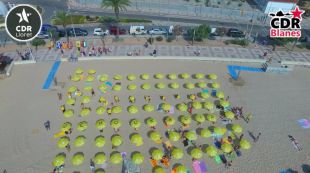 Els CDR de la Selva omplen part de la platja de Blanes de para-sols grocs