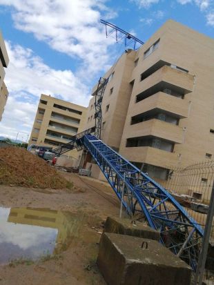Una grua de grans dimensions cau damunt un edifici en construcció a Salt