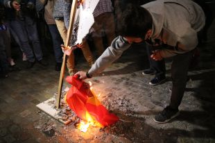 Cremen una figura gegant del rei de cap per avall i una bandera espanyola a Girona