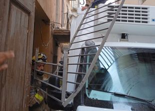 Un camió frigorífic s'emporta un balcó i queda atrapat en un carrer de Girona