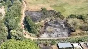 Els Bombers treballen en un incendi forestal prop d'un canal a Anglès