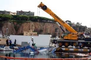 Una gran grua reflota el vaixell enfonsat al port de Sant Feliu de Guíxols 
