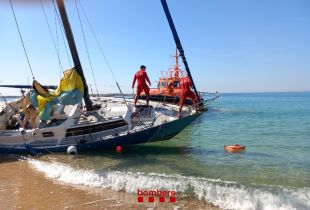 Els Bombers ajuden a remolcar un veler encallat a la platja de Palamós