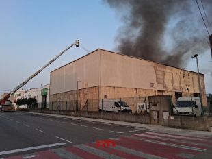 Els Bombers continuen remullant la nau industrial de Vilamalla afectada per l'incendi de dimarts