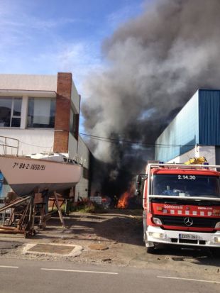 Cremen uns contenidors de brossa al pati exterior d'una nàutica al Port de la Selva 