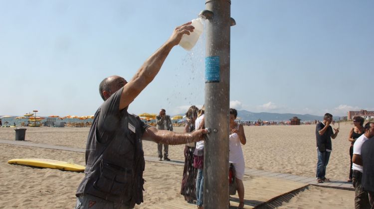 Un dels tècnics, prenent mostres de l'aigua d'una dutxa a la platja Gran de l'Estartit © ACN