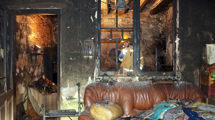 Un Bomber a l'interior de l'habitatge cremat de Santa Coloma de Farners. ACN