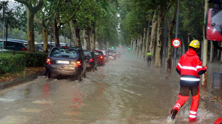 Els cotxes passant per un carrer inundat a la Devesa. ACN