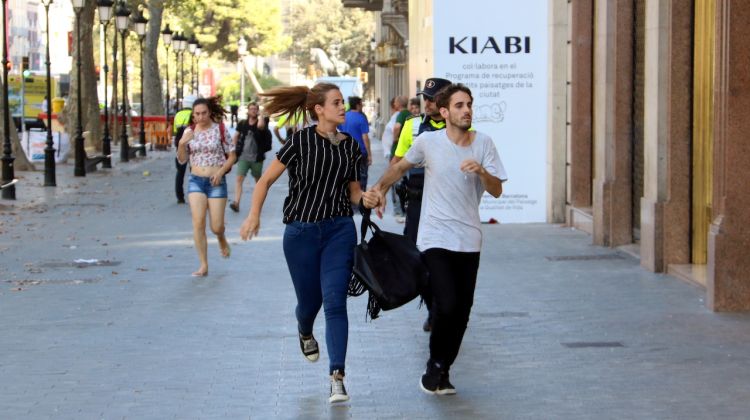 Persones corrent direcció Gran Via per Passeig de Gràcia. ACN