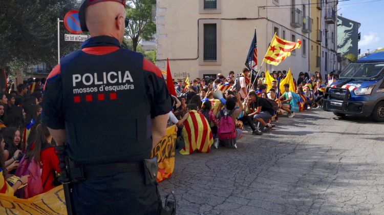 La protesta amb els estudiants de fons i un mosso davant vigilant. ACN