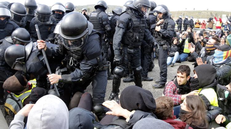 Els mossos fent ús de la força per desallotjar l'autopista. ACN