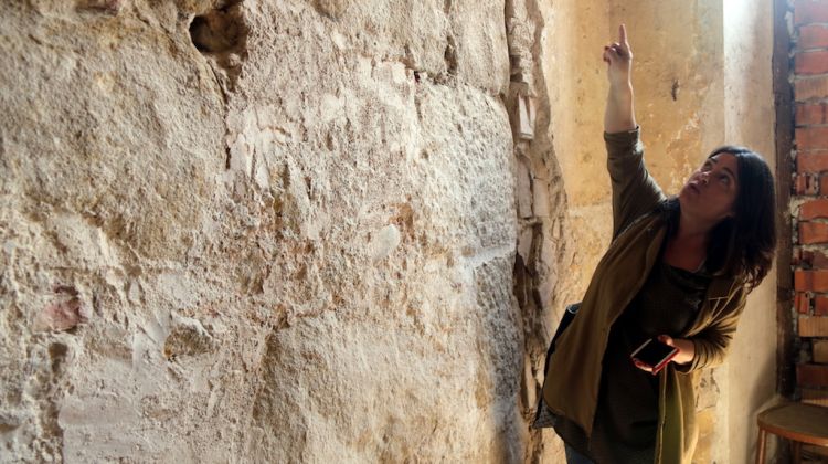 L'arqueòloga Maribel Fuertes aquest 22 de maig del 2018 ensenyant el pany de muralla romana. ACN