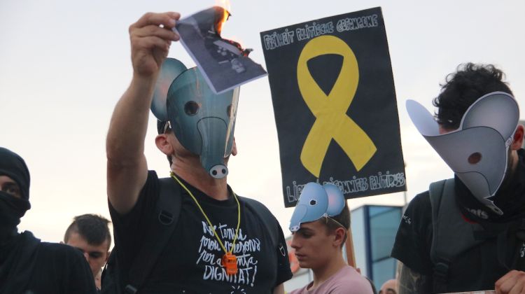 Un manifestant contrari a la presència del Rei a Aiguaviva crema una foto del monarca. ACN