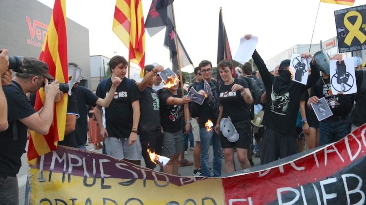 Diverses persones contràries a la presència del Rei a Aiguaviva cremen fotos del monarca. ACN