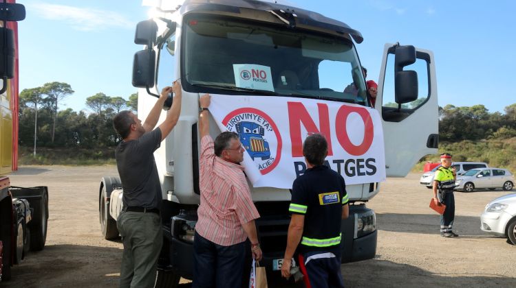 Un grup de transportistes penjant un cartell en un dels tràilers abans de la marxa lenta. ACN