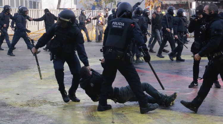 Dos agents dels Mossos, arrossegant un manifestant antifeixista a la plaça U d'Octubre de Girona. ACN