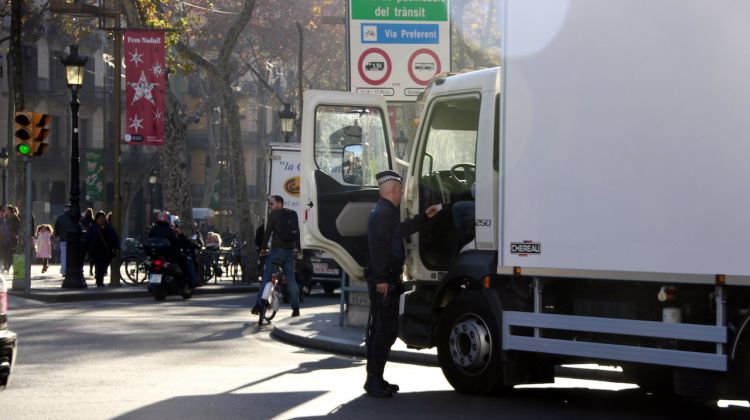 Un agent de la Guàrdia Urbana de Barcelona revisant la documentació d'un transportista al carrer de Pelai amb la Rambla. ACN