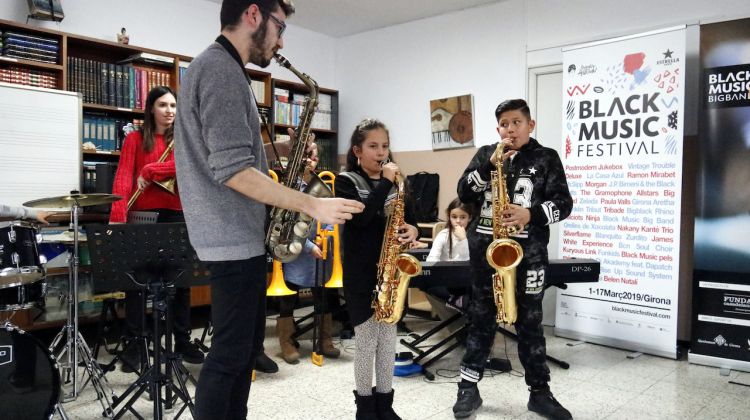 Dos dels estudiants de saxo del projecte Música a l'Est amb el professor en un assaig. ACN