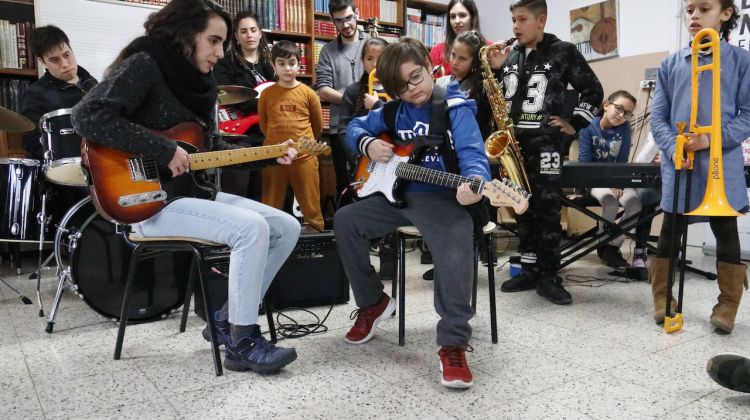 Un dels nens que participa en el projecte Música a l'Est amb la seva professora de guitarra elèctrica assajant. ACN