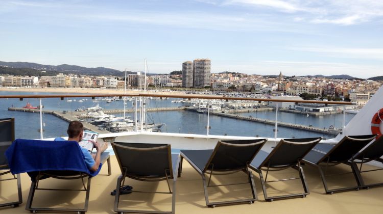 Un turista prenent el sol al primer creuer de la temporada a Palamós. ACN