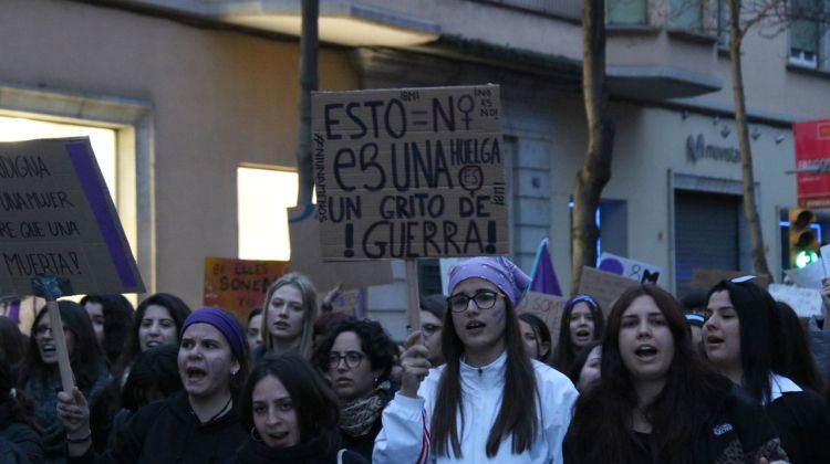 Capçalera de la marxa amb dones portant diverses pancartes en contra del masclisme. ACN