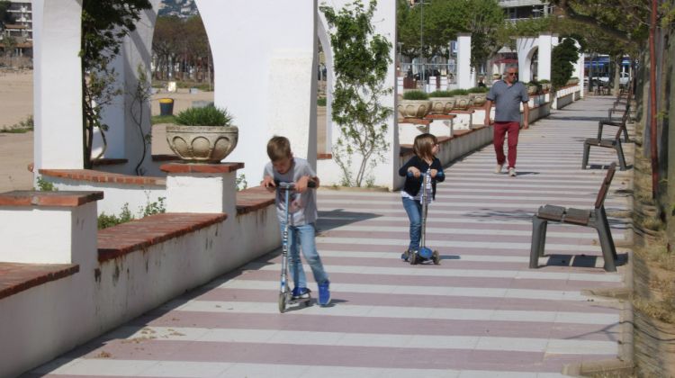 Pla obert del Passeig de Palamós amb dos nens amb un patinet i el seu avi al darrere. Leyre Barceló