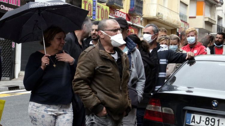 Pla mitjà de les cues per accedir a un estanc del Portús, sense distància de seguretat entre els clients francesos. ACN